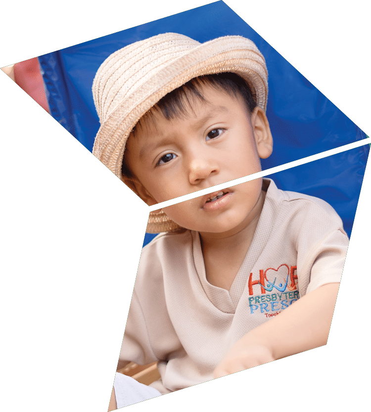 A young boy is sitting in a small wooden cart. Description generated by AI