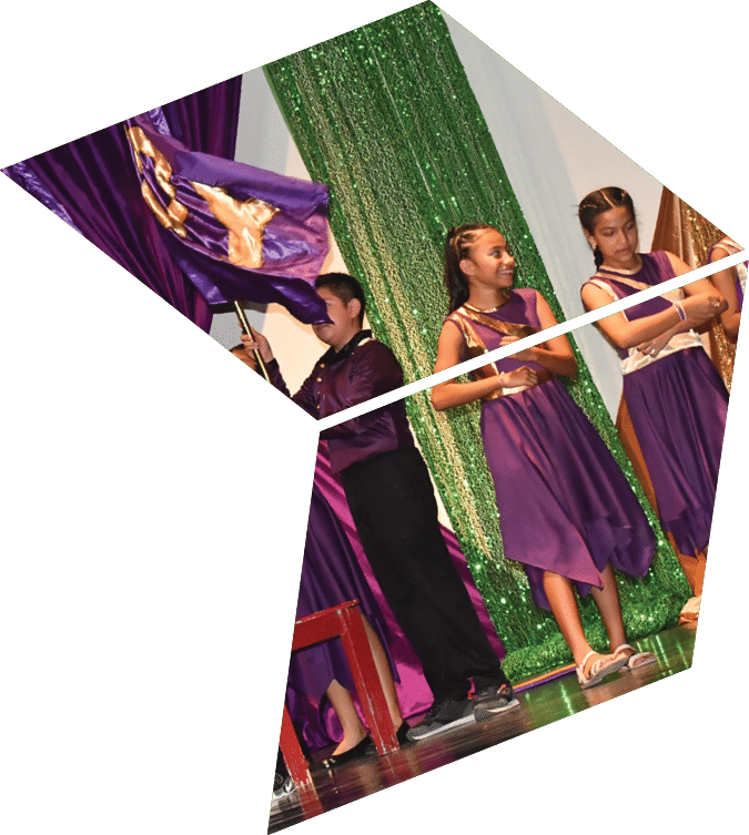 A group of children in purple dresses are performing on stage. Description generated by AI