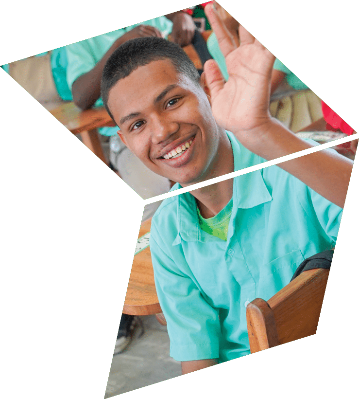 A man in a green shirt is smiling and waving. Description generated by AI